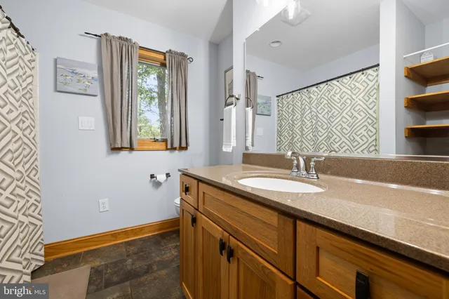 a bed sitting in a spacious bedroom next to a window