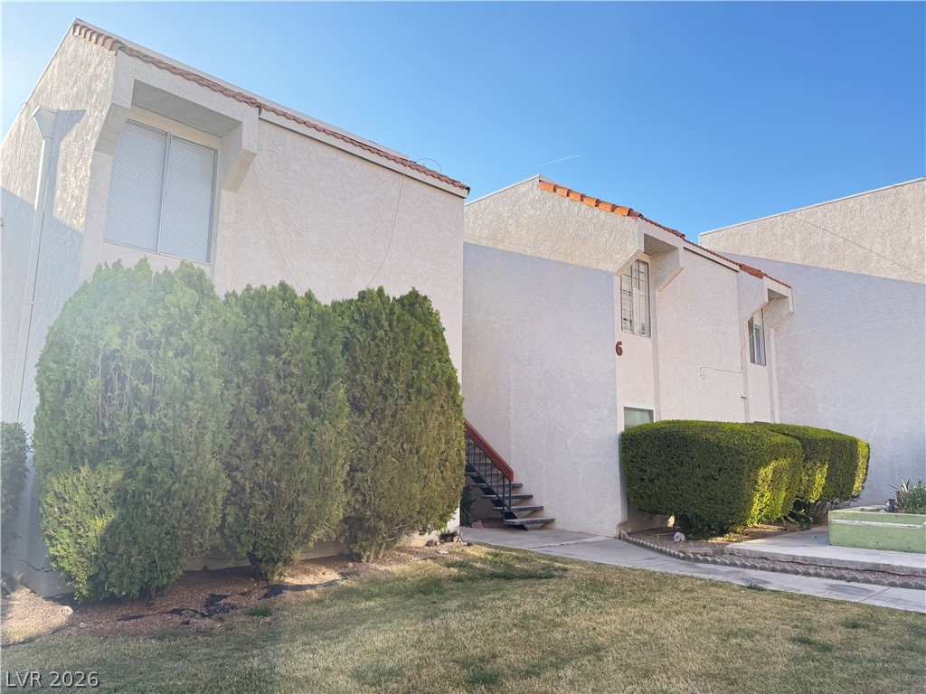 870 B, Unit 604 Boulder City, NV 89005 - Photo 11 of 11 View of home's exterior with stucco siding and a lawn