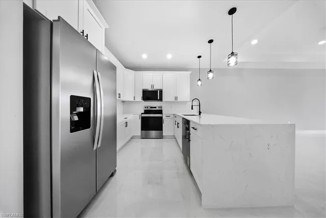 a large kitchen with cabinets and stainless steel appliances