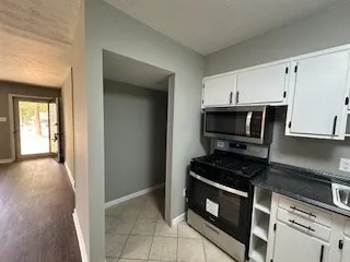 a kitchen with stainless steel appliances a stove a microwave and a hard wood floors