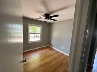 an empty room with windows and fan