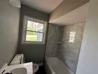 a bathroom with a granite countertop bathtub toilet and sink