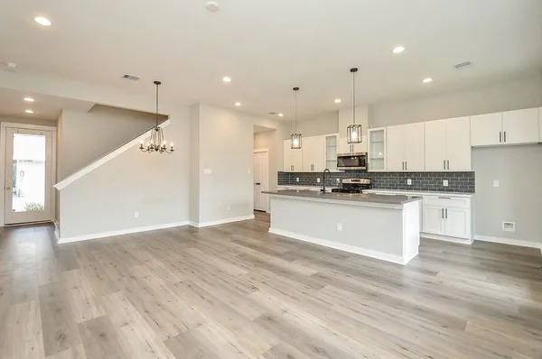 a large kitchen with stainless steel appliances granite countertop a large window a oven a sink and a large island