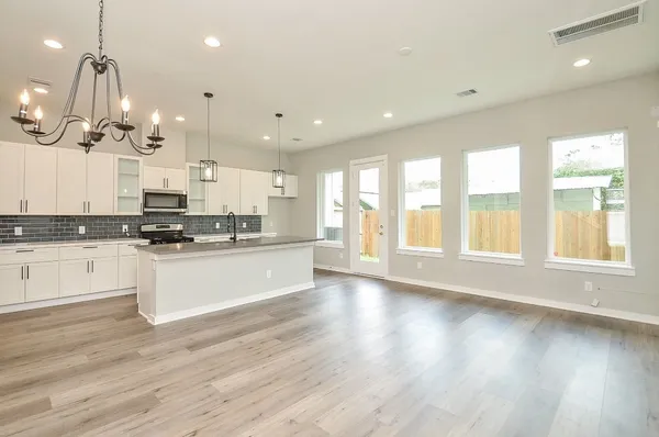 a kitchen with stainless steel appliances granite countertop a sink a stove and a refrigerator