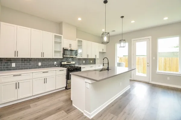 a kitchen with stainless steel appliances granite countertop a sink a oven a counter space and cabinets