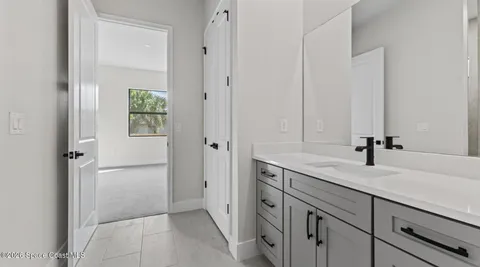 a bathroom with a granite countertop sink a mirror and a shower