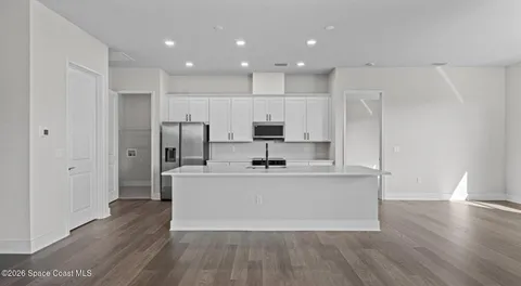 a view of kitchen with sink and refrigerator