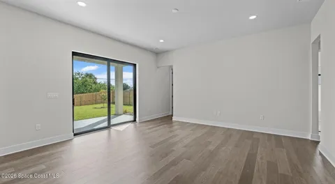a view of an empty room with wooden floor