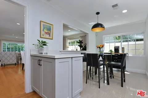 a living room with furniture kitchen view and a wooden floor