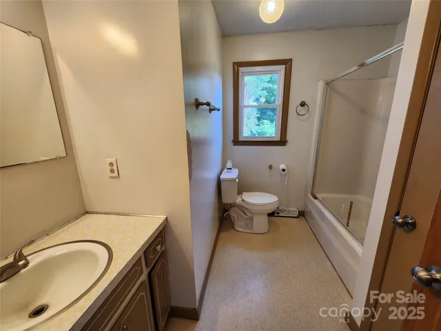 a bathroom with a granite countertop toilet sink and mirror