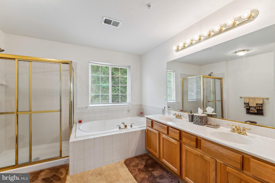 10103 Rolling Green Way Fort Washington, MD 20744 - Photo 24 of 39 a bathroom with a tub sink shower and mirror