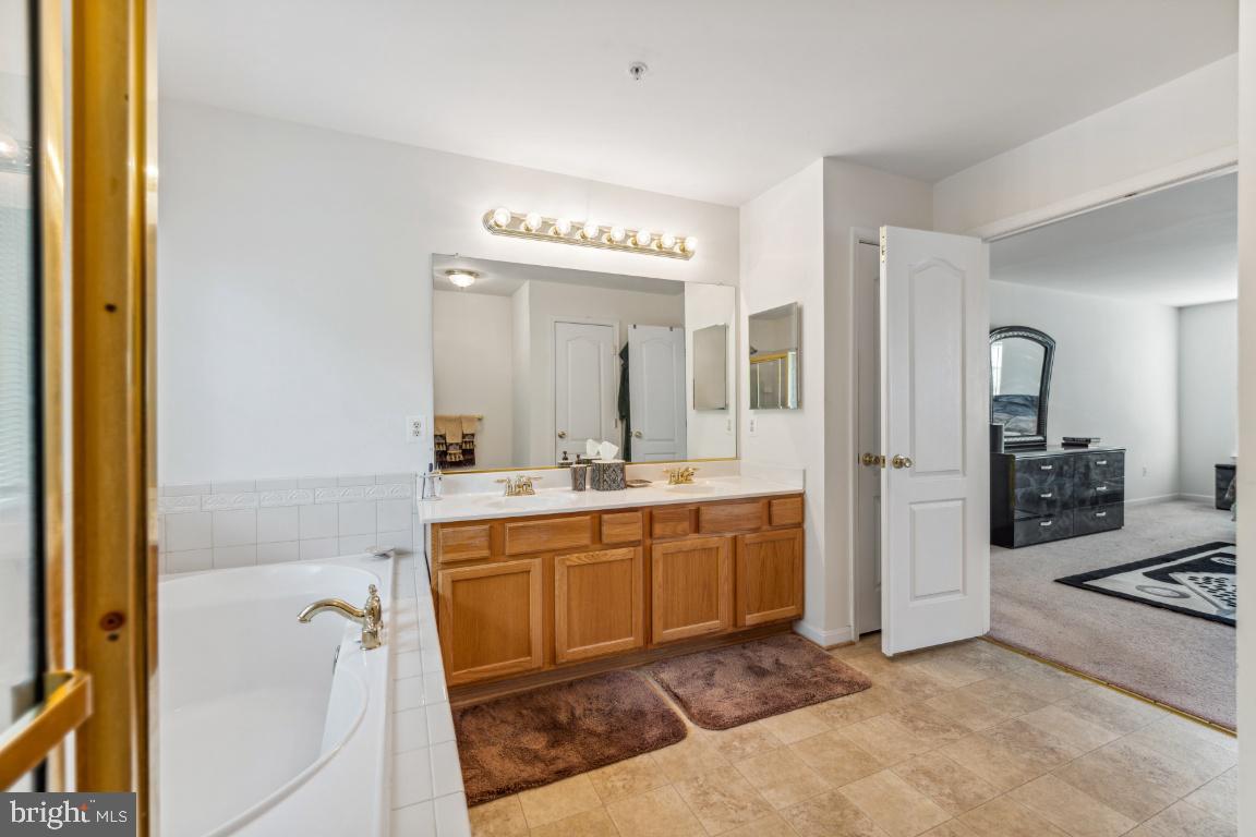 10103 Rolling Green Way Fort Washington, MD 20744 - Photo 25 of 39 a spacious bathroom with a tub sink and mirror