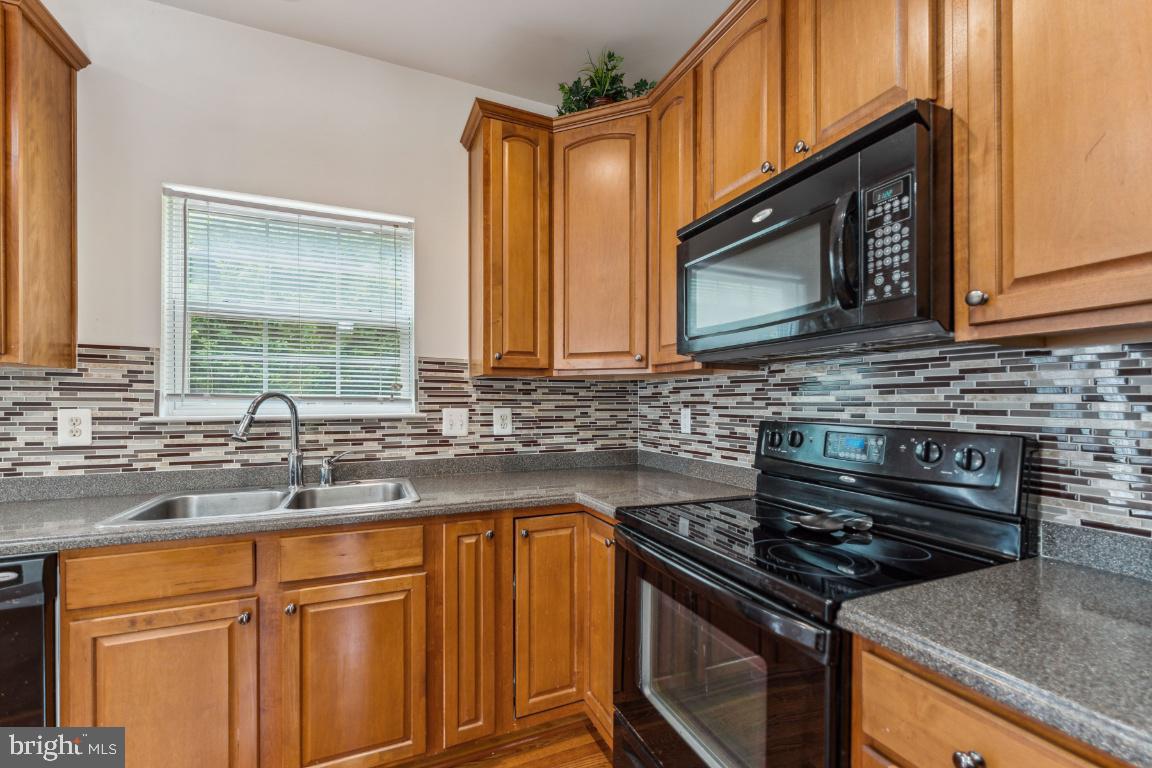 10103 Rolling Green Way Fort Washington, MD 20744 - Photo 10 of 39 a kitchen with stainless steel appliances granite countertop a sink stove and microwave