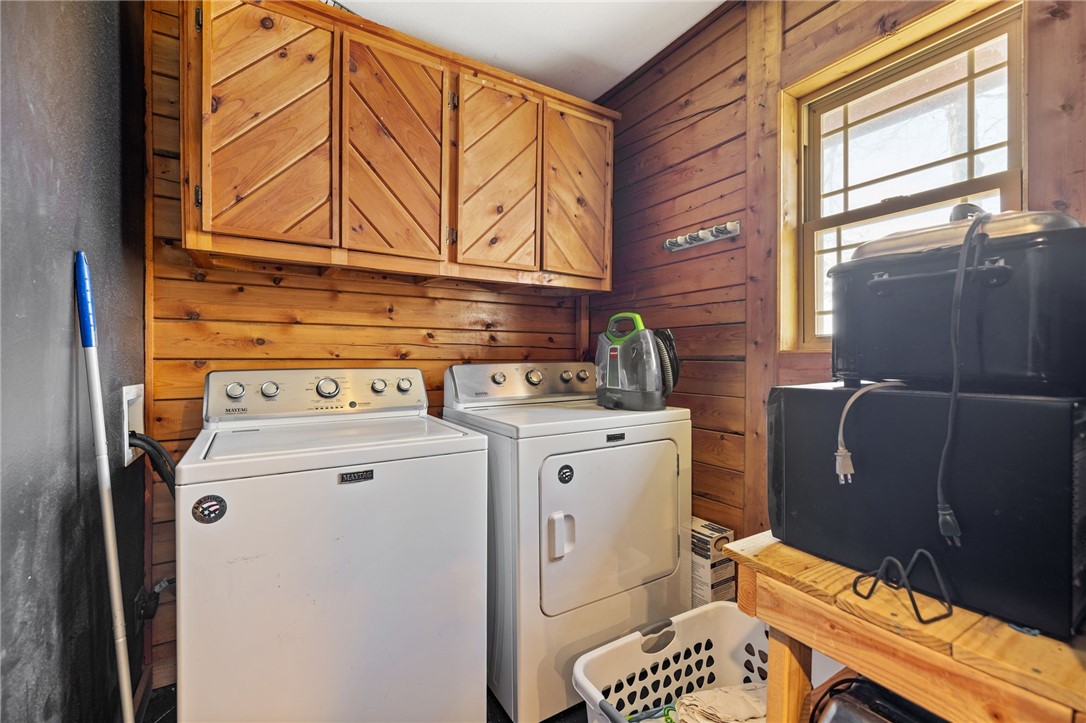 10557 North Devils Den Road Winslow, AR 72959 - Photo 30 of 60 Laundry room featuring wood walls, independent washer and dryer, and cabinet space