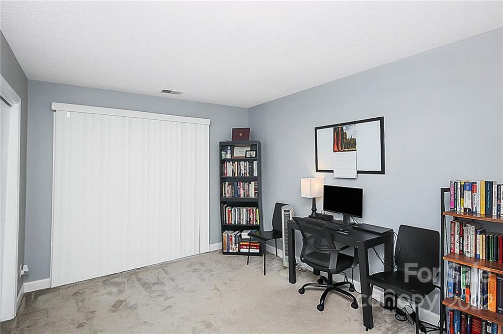 1612 Sharon Road West Charlotte, NC 28210 - Photo 22 of 25 a view of a workspace with furniture and a bookshelf