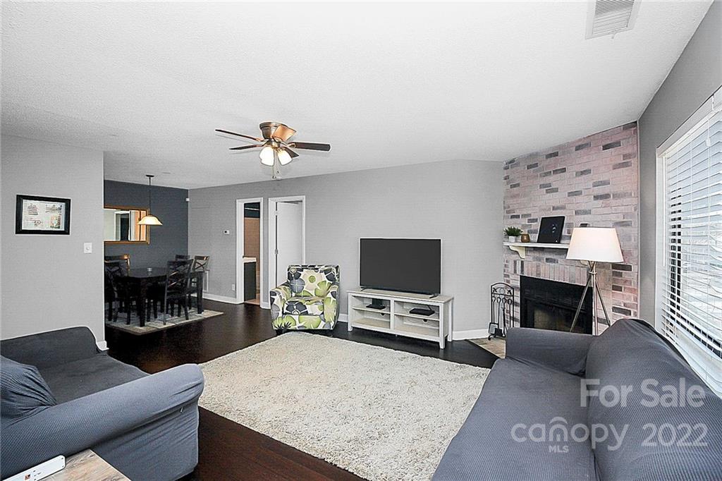 1612 Sharon Road West Charlotte, NC 28210 - Photo 5 of 25 a living room with furniture a fireplace and a flat screen tv