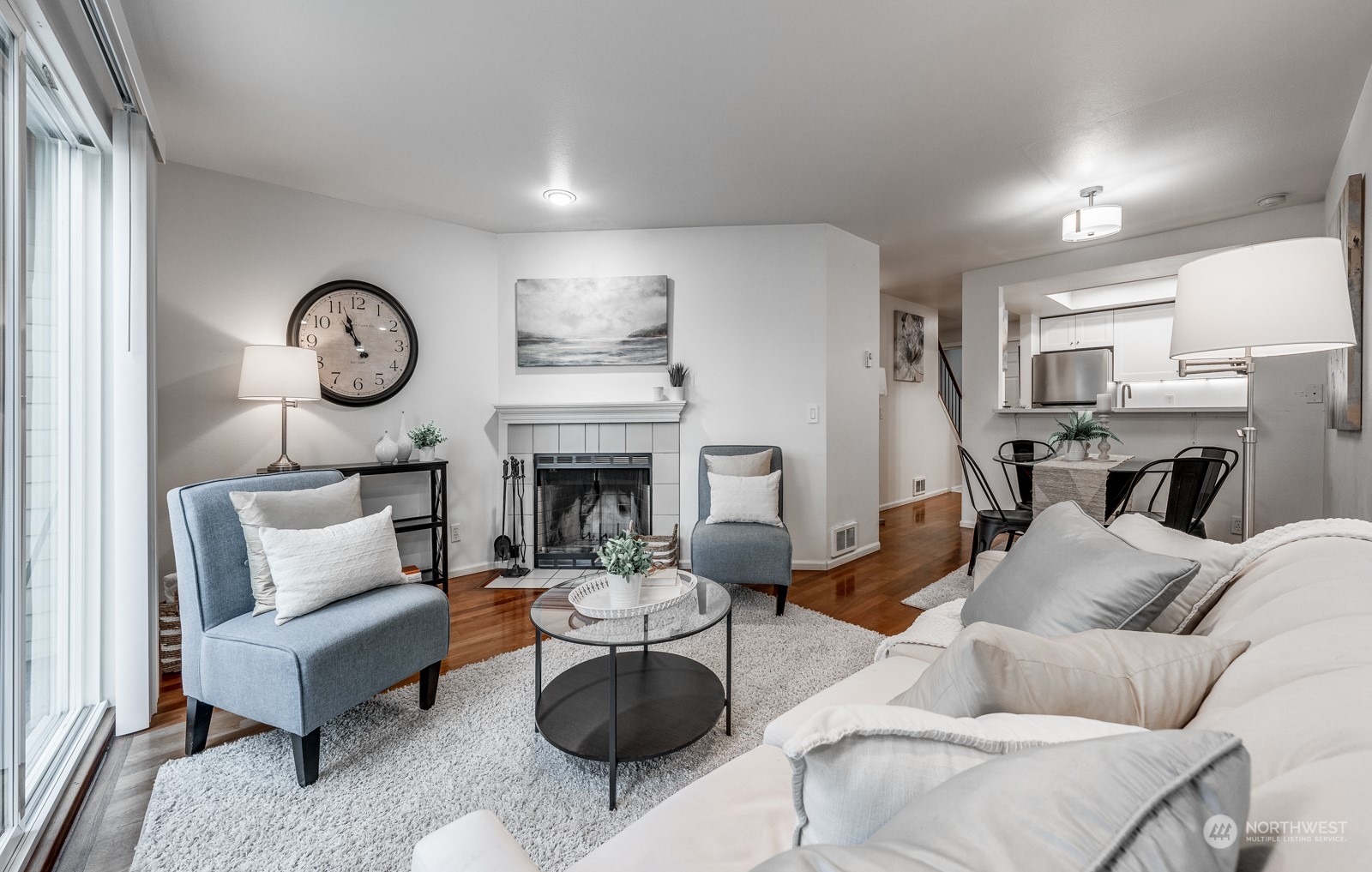 8512 242nd Street Southwest, Unit 9 Edmonds, WA 98026 - Photo 12 of 26 a living room with furniture a fireplace and a clock