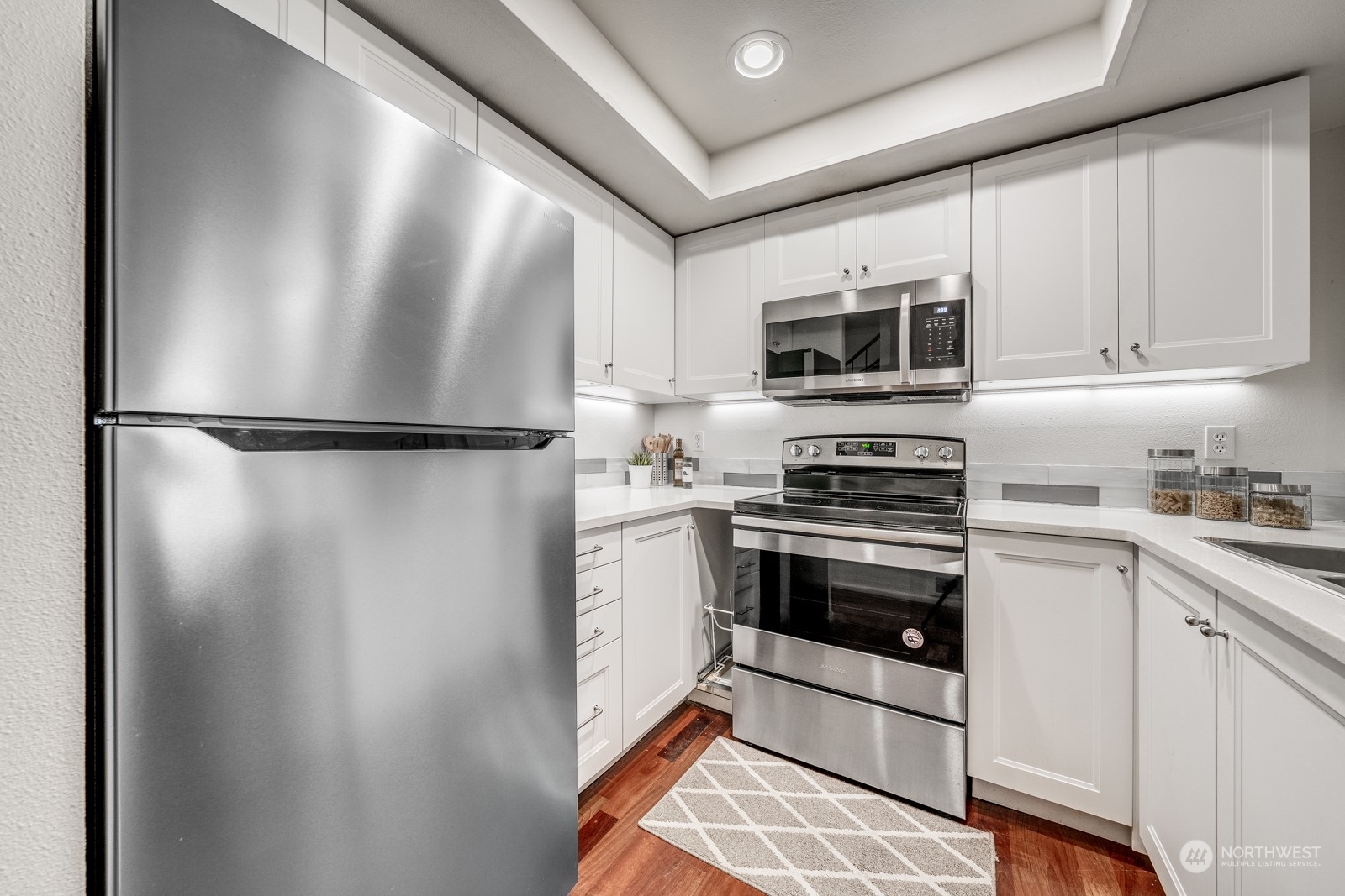 8512 242nd Street Southwest, Unit 9 Edmonds, WA 98026 - Photo 7 of 26 a kitchen with a refrigerator and a stove top oven