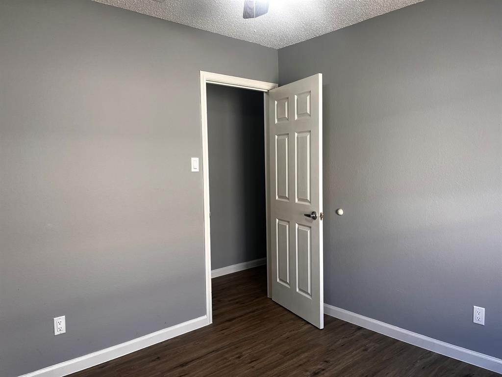 1007 Mack Place Denton, TX 76209 - Photo 29 of 37 Unfurnished room featuring dark wood-type flooring, a ceiling fan, and a textured ceiling