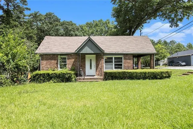 a front view of a house with a garden and plants