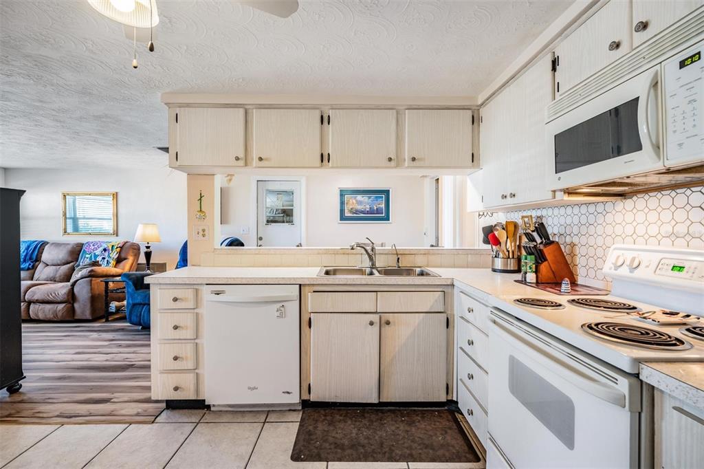 3608 Umber Road Holiday, FL 34691 - Photo 8 of 20 a kitchen with white cabinets sink and white appliances