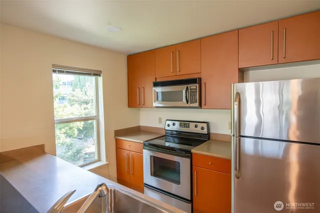 a kitchen with stainless steel appliances granite countertop a refrigerator sink and stove