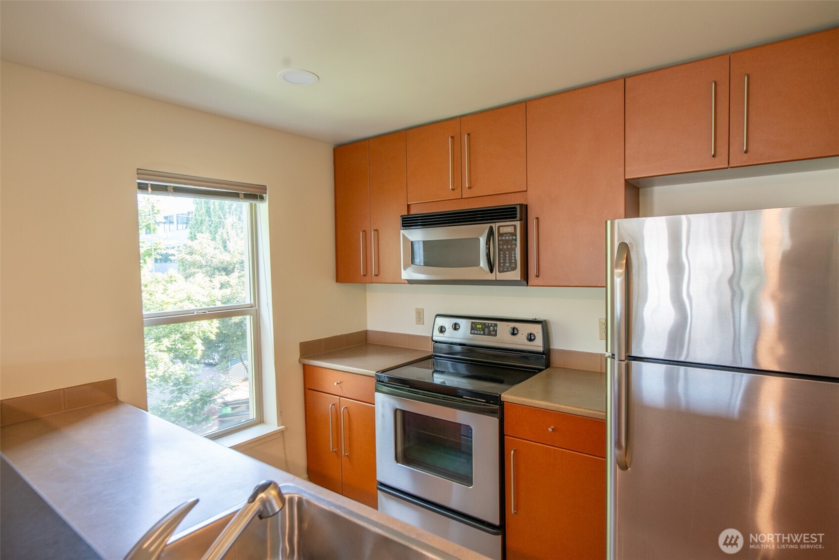 1550 Eastlake Avenue East, Unit 201 Seattle, WA 98102 - Photo 20 of 30 a kitchen with stainless steel appliances granite countertop a refrigerator sink and microwave