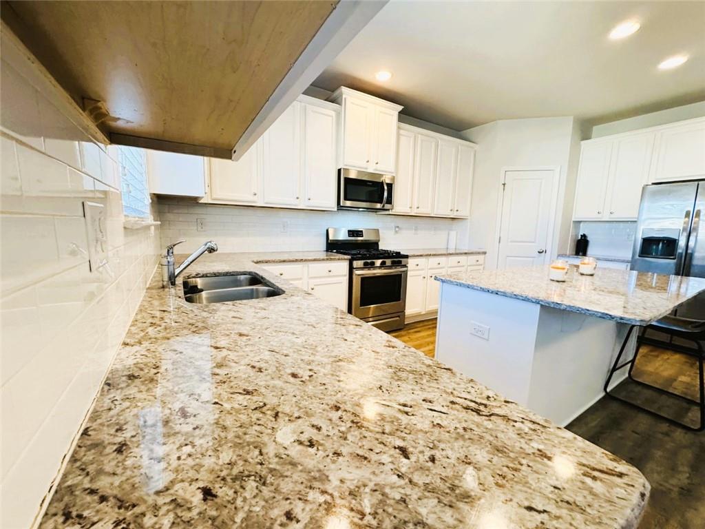 142 Wentworth Lane Villa Rica, GA 30180 - Photo 14 of 44 a kitchen with a stove a sink and a refrigerator