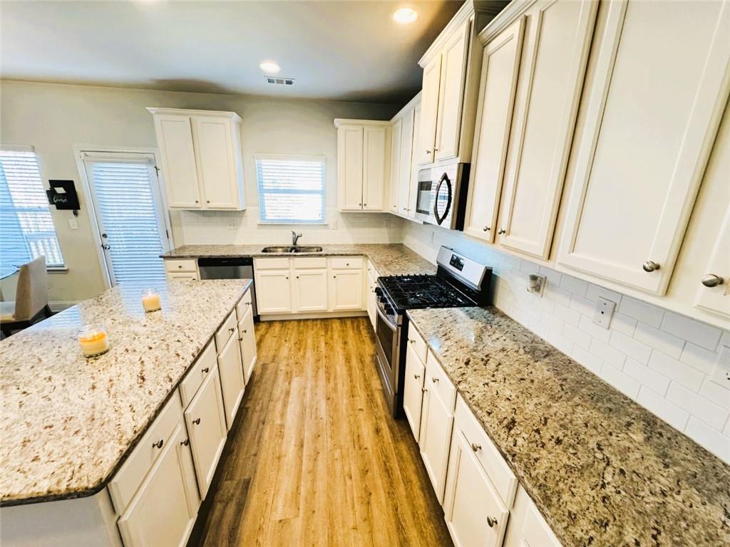 142 Wentworth Lane Villa Rica, GA 30180 - Photo 15 of 44 a kitchen with a stove a sink a microwave a counter top space and cabinets