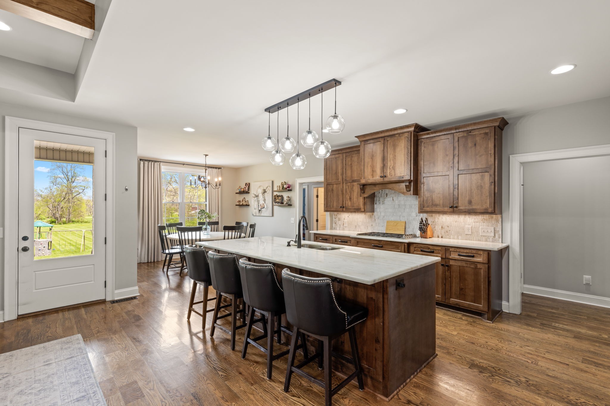 6012 Bethlehem Road Springfield, TN 37172 - Photo 13 of 60 a kitchen with stainless steel appliances granite countertop a stove a refrigerator a microwave oven a dining table and chairs with wooden floor