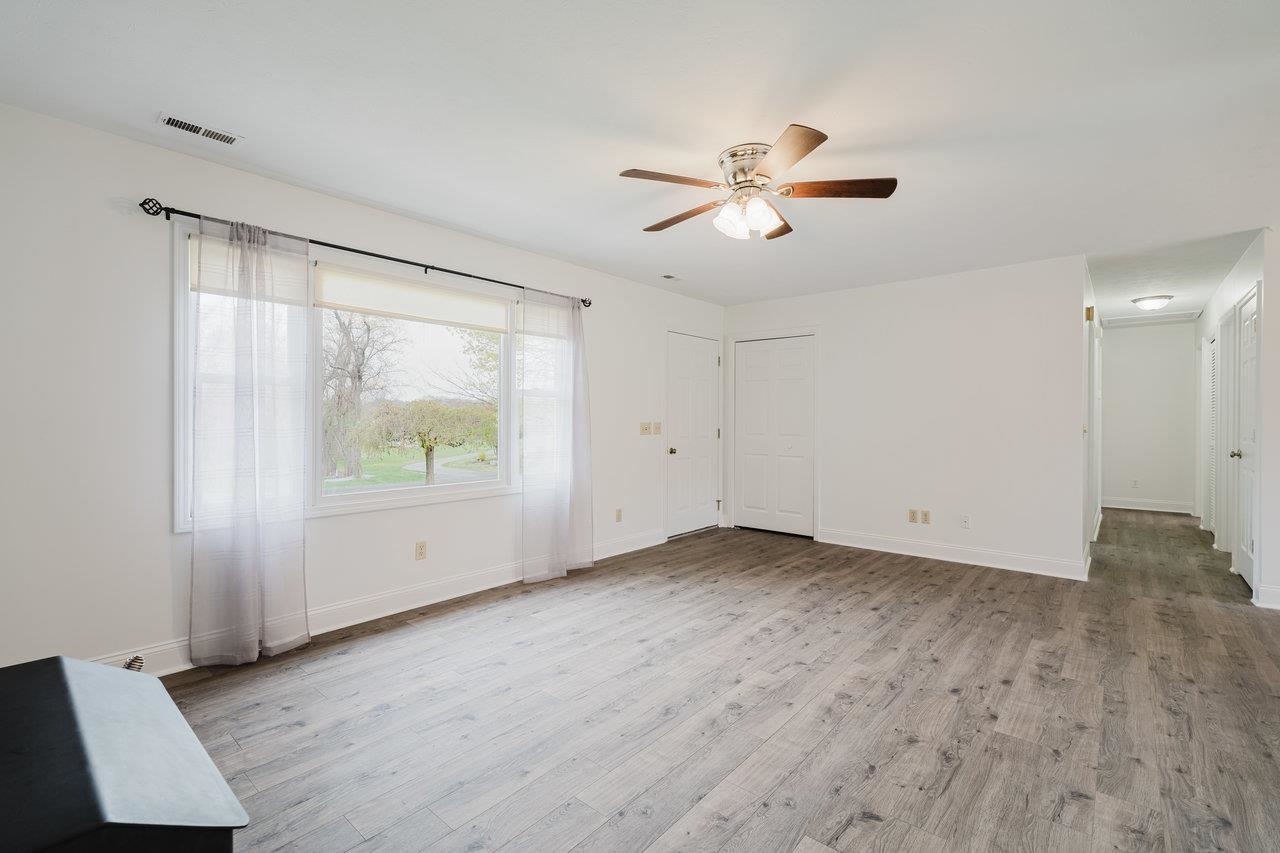 2407 Spaders Church Road Harrisonburg, VA 22801 - Photo 6 of 32 a view of an empty room with wooden floor and a window