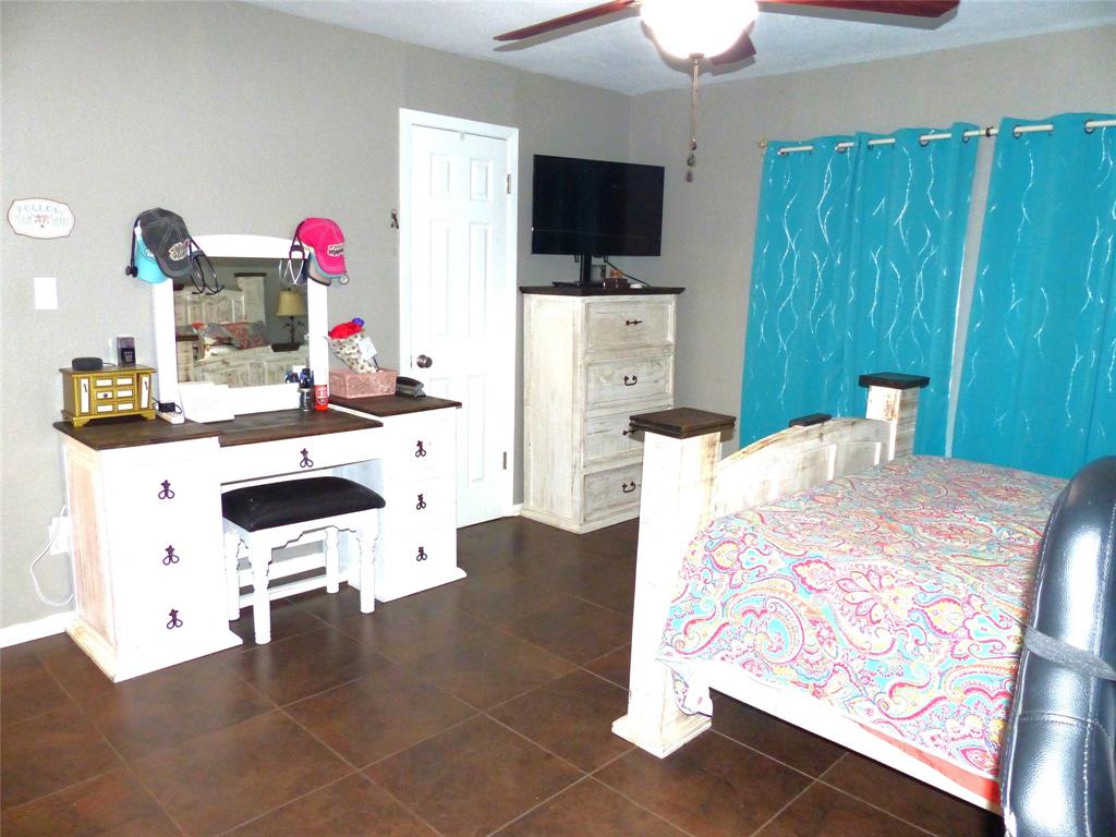 703 Gay Street Menard, TX 76859 - Photo 22 of 37 a bedroom with a bed and a flat screen tv