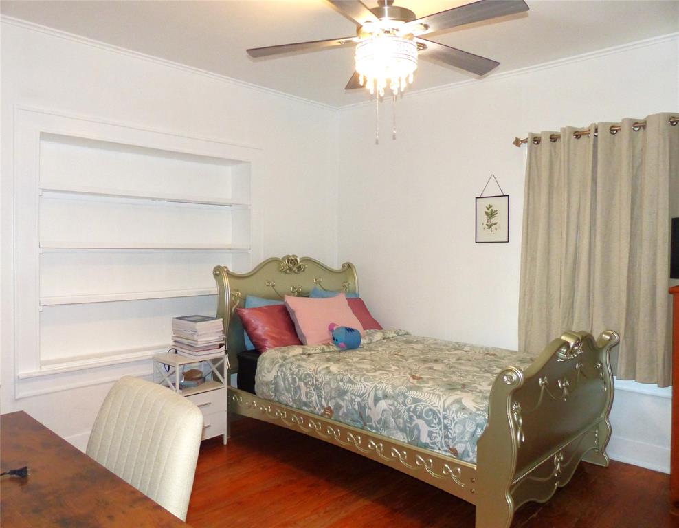 703 Gay Street Menard, TX 76859 - Photo 32 of 37 a bedroom with a bed and a chandelier