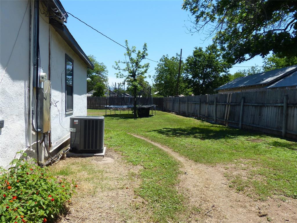 703 Gay Street Menard, TX 76859 - Photo 35 of 37 a view of a backyard with potted plants and a large tree