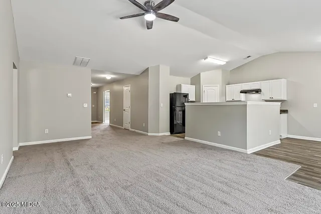 an empty room with closet and a ceiling fan