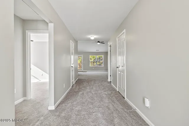 an empty room with a window and a fan
