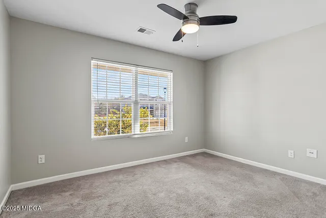 an empty room with closet and a chandelier fan