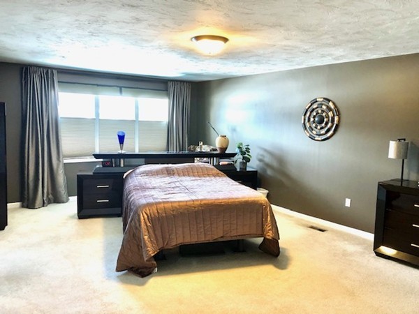 113 Ariel Circle, Unit 113 Sutton, MA 01590 - Photo 18 of 39 a spacious bedroom with a bed and a table