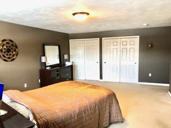 113 Ariel Circle, Unit 113 Sutton, MA 01590 - Photo 20 of 39 a bed sitting in a bedroom and a flat tv screen on dresser