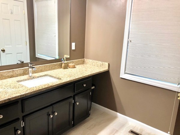 113 Ariel Circle, Unit 113 Sutton, MA 01590 - Photo 22 of 39 a bathroom with a granite countertop sink and a mirror