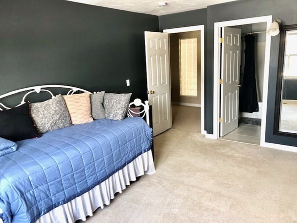 113 Ariel Circle, Unit 113 Sutton, MA 01590 - Photo 24 of 39 a bedroom with a bed and a mirror