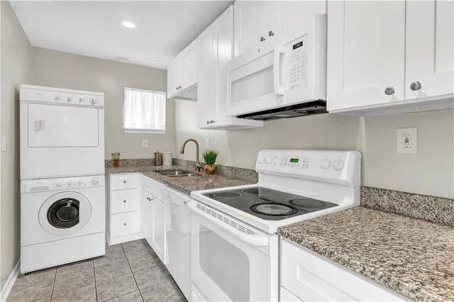 a kitchen with white cabinets and sink