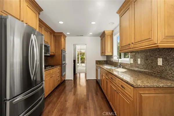 a large kitchen with hardwood and stainless steel appliances