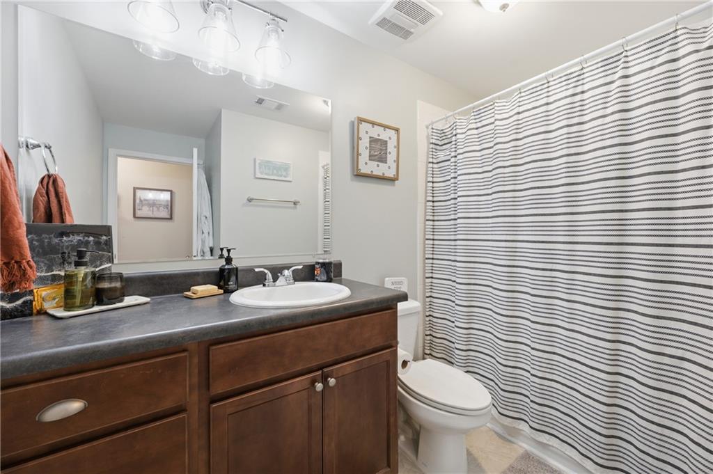 1007 Olde Mill Lane Norcross, GA 30093 - Photo 25 of 32 a bathroom with a granite countertop toilet sink and mirror