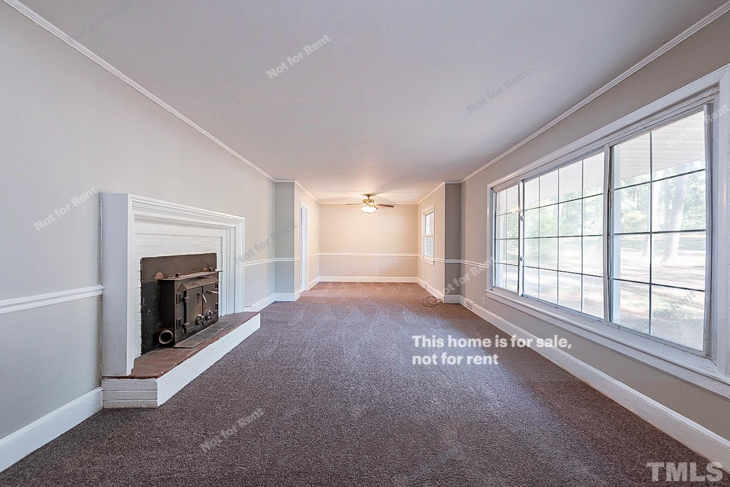 116 Ridge Road Butner, NC 27509 - Photo 2 of 16 a view of an empty room with a fireplace and a window