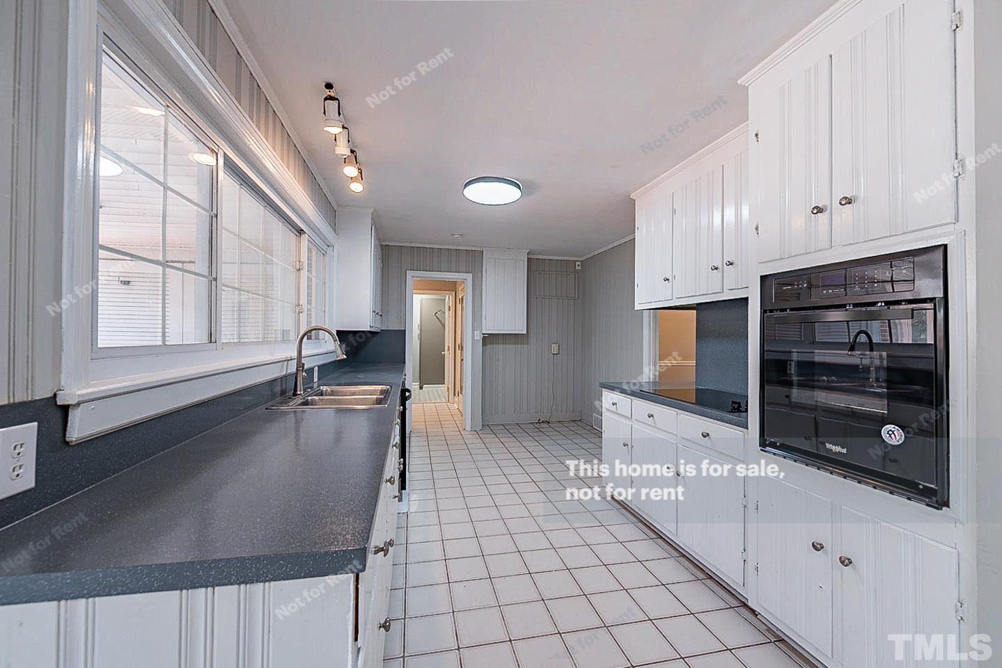 116 Ridge Road Butner, NC 27509 - Photo 5 of 16 a kitchen with stainless steel appliances a stove a sink and white cabinets with wooden floor