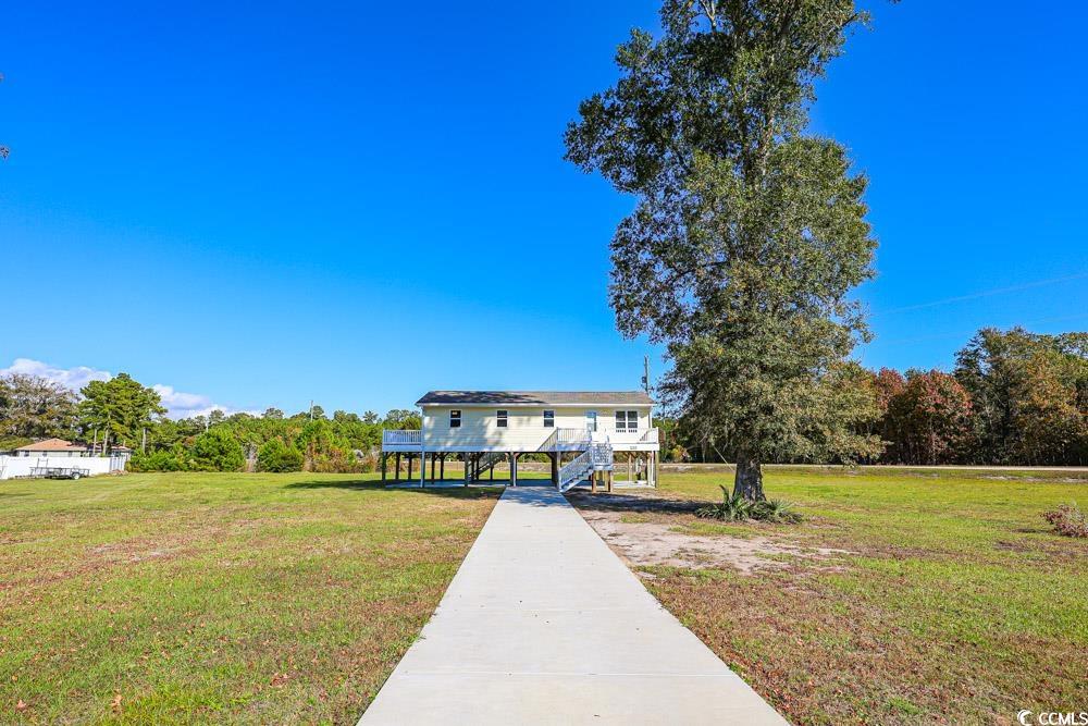 200 Math Place Little River, SC 29566 - Photo 34 of 40 Coastal home featuring a front lawn, stairway, and view of scattered trees