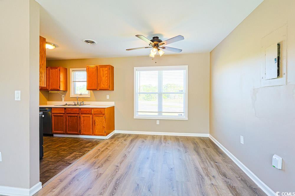 200 Math Place Little River, SC 29566 - Photo 7 of 40 Kitchen with light countertops, brown cabinetry, a ceiling fan, and dark wood-type flooring