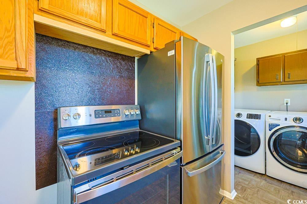 200 Math Place Little River, SC 29566 - Photo 10 of 40 Kitchen featuring stainless steel appliances, independent washer and dryer, and brown cabinetry