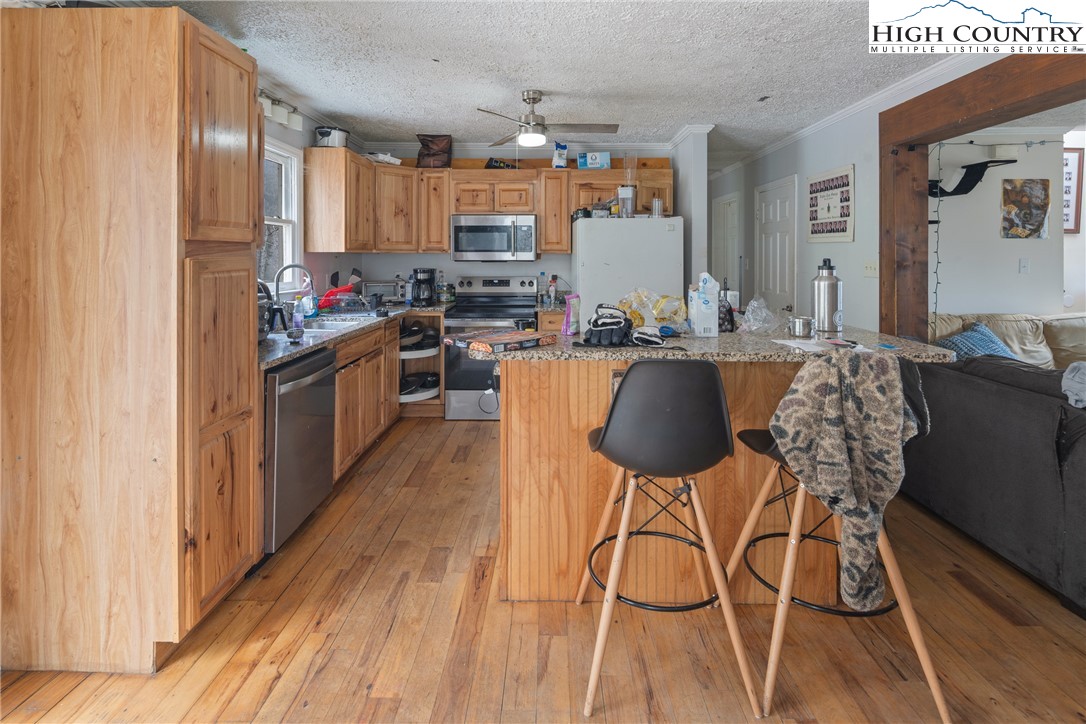 656 Winterberry Trail Boone, NC 28607 - Photo 10 of 47 a kitchen with stainless steel appliances granite countertop a kitchen island hardwood floor sink stove dining table and chairs